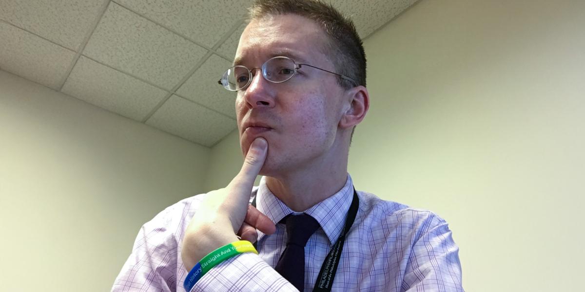 Alex Grieco portrait with thumb on chin thoughtfully